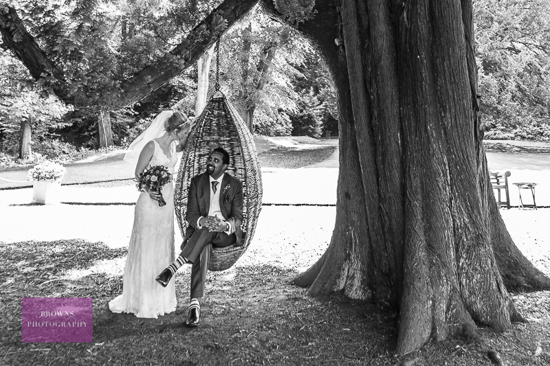 Bride and groom on tree seat at Eshott Hall