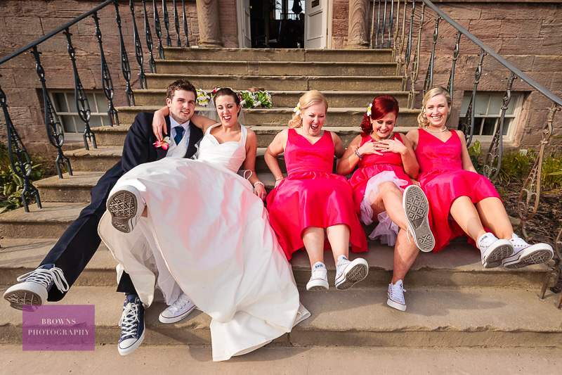 Bride, groom and bridesmaids showing off their wedding sneakers on their wedding day at Newton Hall
